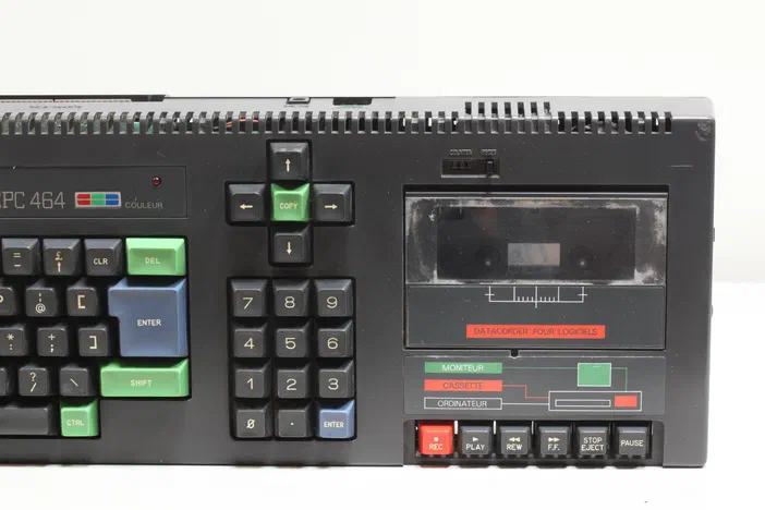 Ordinateur Amstrad CPC 464 vu de face, montrant son clavier à touches colorées et sa cassette de données latérale.