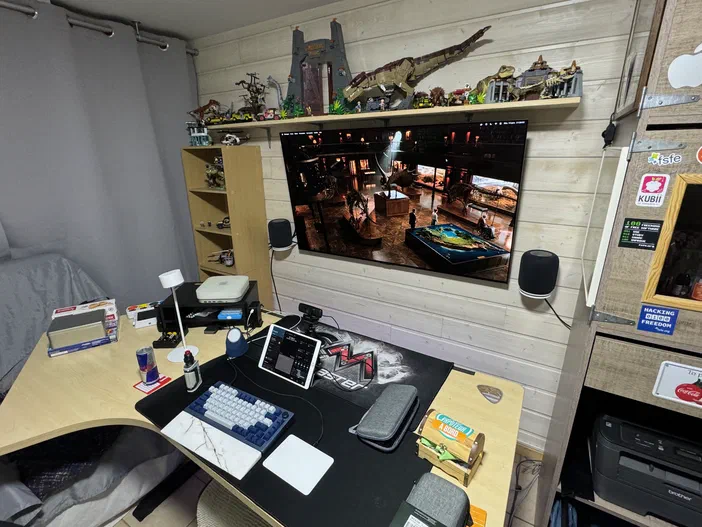 Bureau informatique avec clavier, tablette et téléviseur affichant un musée de dinosaures