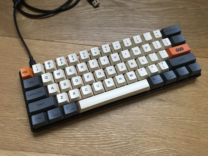 Clavier mécanique custom avec des touches blanches et grises sur un fond en bois