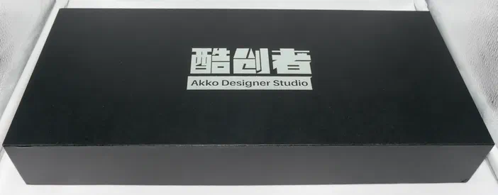 Coffret noir rectangulaire avec l'inscription 'Akko Designer Studio' en blanc.