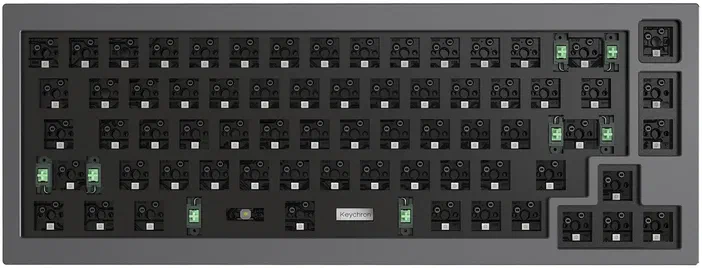 Vue de dessus d'un clavier mécanique noir avec des interrupteurs visibles sous chaque touche et quelques touches vertes.