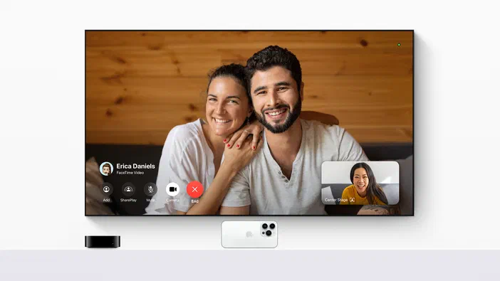 Un couple souriant participe à une visioconférence sur un écran, avec des icônes de contrôle en bas.