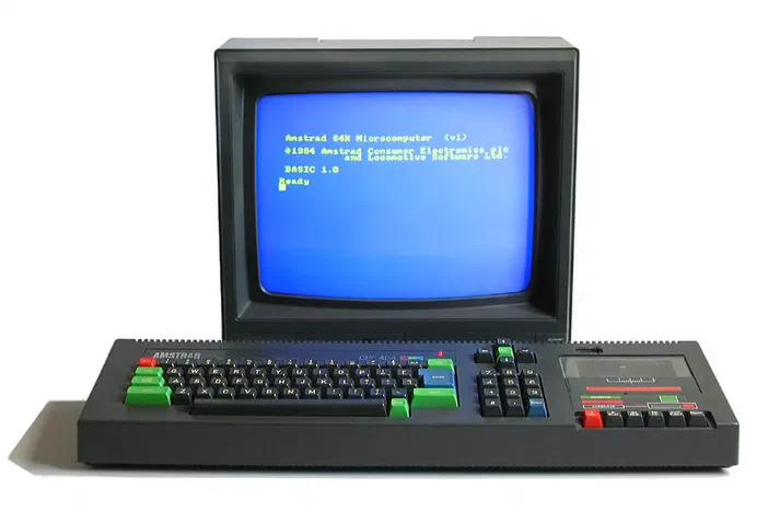 Ordinateur Amstrad CPC 464 de 1984 avec écran bleu affichant le logo BASIC et clavier noir.