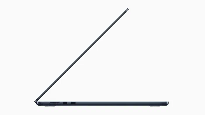 Vue de profil d'un ordinateur portable ouvert, montrant sa finesse et ses ports latéraux.