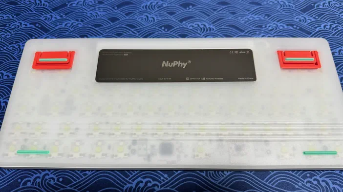 Le dessous d'un clavier NuPhy Air75 V2, avec sa plaque et ses béquilles visibles